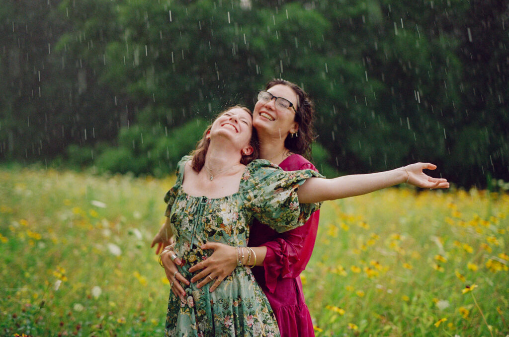 Lesbian couple, Charlotte & Lilly, during their engagement session at World's End in Hingham Massachusetts as it begin to rain